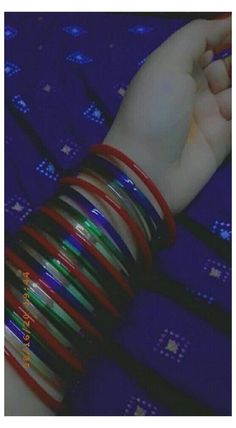 a woman's arm with several bracelets on it