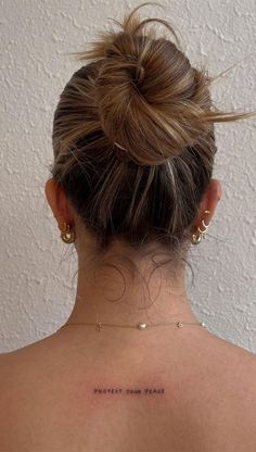 the back of a woman's head, with her hair in a high bun