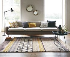 a living room filled with furniture and decor on top of a hard wood floored floor