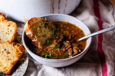 a bowl of soup with bread on the side