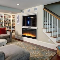 a living room filled with furniture and a flat screen tv mounted to the wall above a fire place