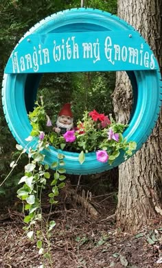 a sign that says hangin with my gnomes hanging from the side of a tree