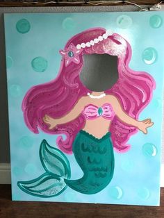 a painting of a mermaid with pink hair and pearls on it's head is shown