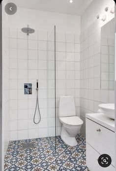 a white toilet sitting next to a walk in shower