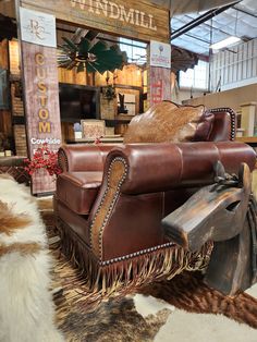 an old leather chair with fringes on it in a showroom area at a furniture store