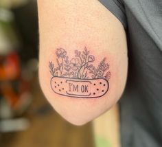 a person with a flower pot tattoo on their left arm that says i'm ok