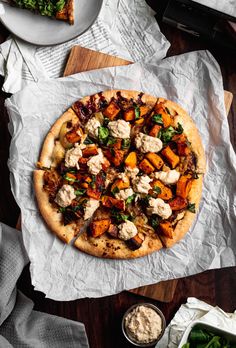 roasted butternut squash and caramelized onion pizza on parchment paper with text overlay that reads roasted butternut squash and caramelized onion pizza