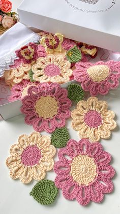 crocheted flowers are on the table next to a box