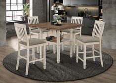 a kitchen table with four chairs and a rug on the floor in front of it