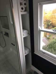 a bathroom with toilet paper on the shelves