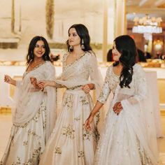 three women in white dresses standing next to each other