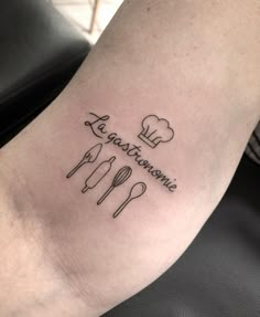 a tattoo on the leg of a woman with words and utensils in cursive writing