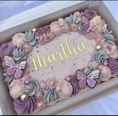 a birthday cake decorated with pink and purple flowers, butterflies and the word mahlha