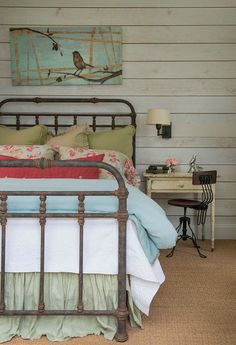 a bed room with a neatly made bed and a painting on the wall above it