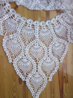 a white crocheted doily on a wooden floor