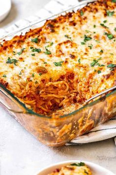 a casserole dish filled with spaghetti and topped with parsley