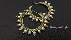 a pair of hoop earrings with pearls and green beads on a black leather background photo