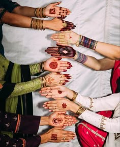 a group of women with their hands painted in hendi designs and bracelets on