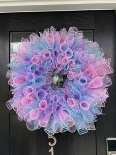 a purple and blue mesh wreath hanging on a door with the number 1 in front of it