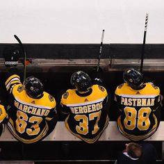 three hockey players are sitting on the bench and waiting for their next game to begin