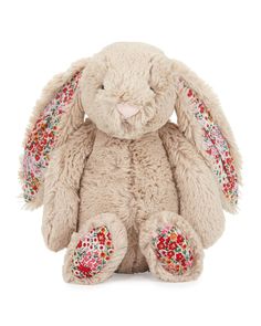 a stuffed rabbit with colorful sequins on it's ears and tail, sitting in front of a white background