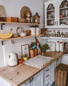 a kitchen with wooden counter tops and white cabinets