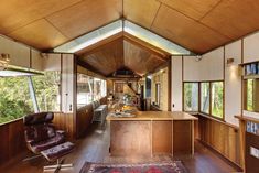 the interior of a modern home with wood paneling and vaulted ceiling, along with leather chairs