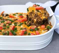 a casserole dish with meat and vegetables being lifted from the casserole