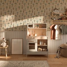 a child's play kitchen with palm trees on the wall and shelves above it