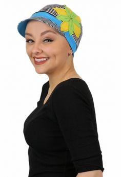 a woman wearing a blue and yellow head wrap with flowers on it's side