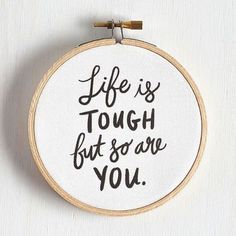 a cross stitch hoop with the words life is tough but so are you