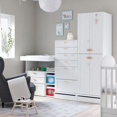 a baby's room with white furniture and lots of storage space in the corner