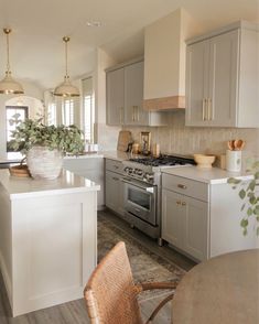 a kitchen with white cabinets and silver appliances