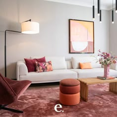 a living room with white couches and pink rugs on the floor in front of a painting