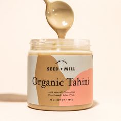 a spoon full of organic tahiti sitting on top of a jar of mayonnaise