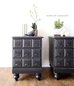 two black dressers sitting next to each other on top of a wooden floor