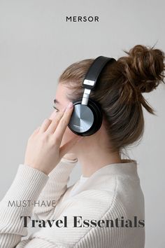 a woman wearing headphones with the words must have travel essentials on her ear