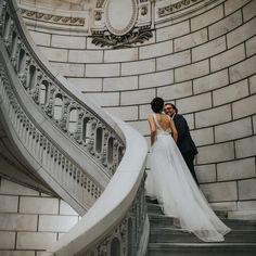 a bride and groom are standing on the stairs