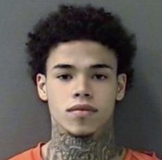 a young man with tattoos on his neck is looking at the camera while wearing an orange shirt