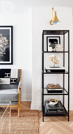 a living room filled with furniture and a book shelf on top of a hard wood floor