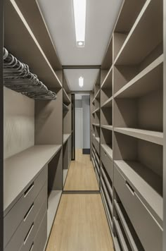 an empty walk - in closet with lots of shelves and drawers on each side,