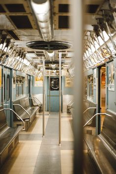 the inside of a subway car with benches and railings