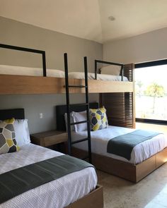 two beds in a room with bunk beds next to each other and windows overlooking the beach