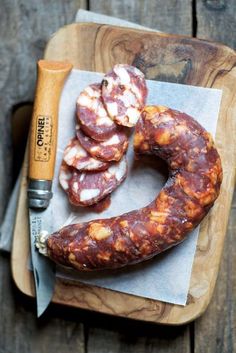 some sausages are on a cutting board with a knife