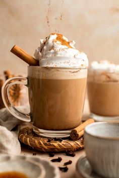 two mugs filled with hot chocolate and whipped cream on top of eachother