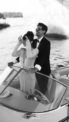 a man and woman standing on the back of a boat