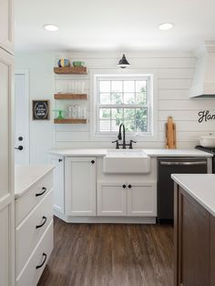 a kitchen with white cabinets and wood floors is pictured in this image from the inside