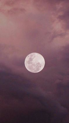 the full moon is seen through dark clouds