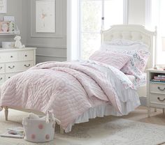 a bedroom with white furniture and pink comforter