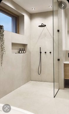 a bathroom with a walk in shower next to a sink and mirror on the wall